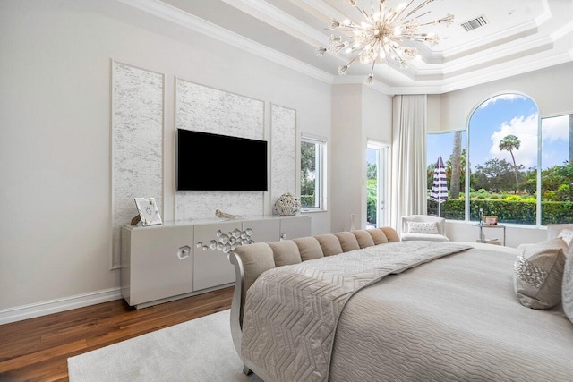 bedroom with a tray ceiling, multiple windows, hardwood / wood-style floors, and ornamental molding