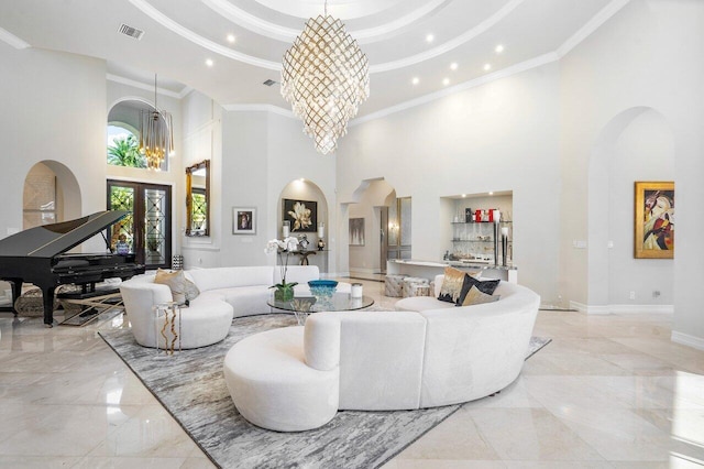 living room with crown molding, a towering ceiling, and an inviting chandelier