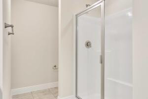 bathroom featuring tile patterned flooring and an enclosed shower