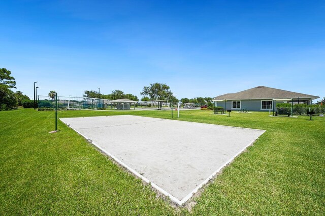 surrounding community with volleyball court and a lawn