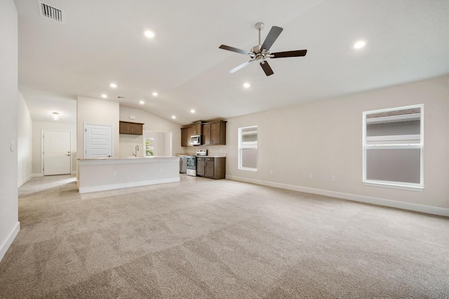 unfurnished living room with light carpet, sink, ceiling fan, and vaulted ceiling