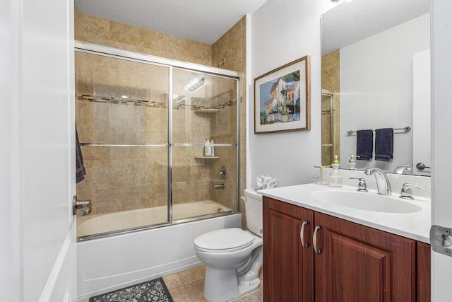 full bathroom featuring a textured ceiling, enclosed tub / shower combo, tile patterned floors, vanity, and toilet