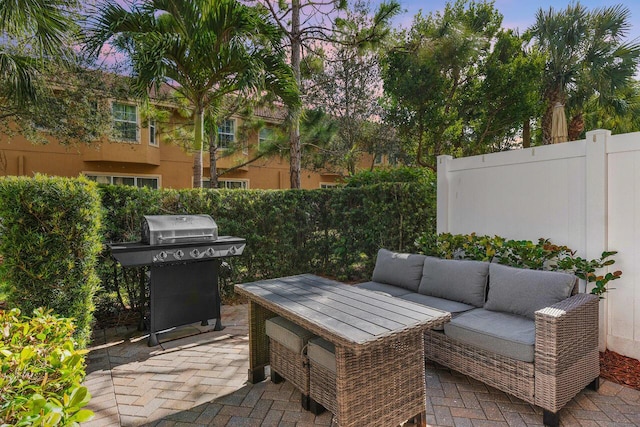 patio terrace at dusk featuring outdoor lounge area and area for grilling