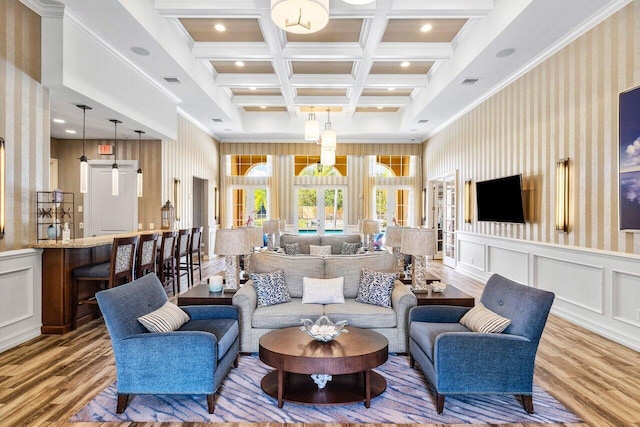 living room featuring a barn door, hardwood / wood-style floors, coffered ceiling, ornamental molding, and beam ceiling