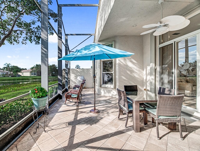 view of patio with glass enclosure and ceiling fan