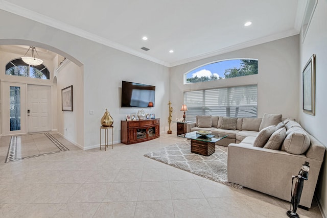 tiled living room with crown molding and high vaulted ceiling