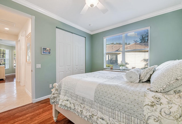 bedroom featuring hardwood / wood-style flooring, ceiling fan, a closet, and multiple windows