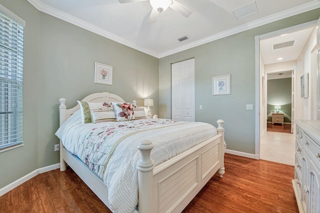 bedroom with ceiling fan, a closet, dark hardwood / wood-style floors, and ornamental molding