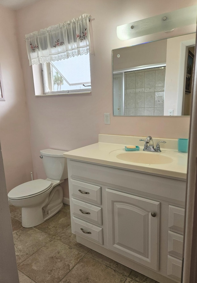 bathroom with walk in shower, vanity, and toilet