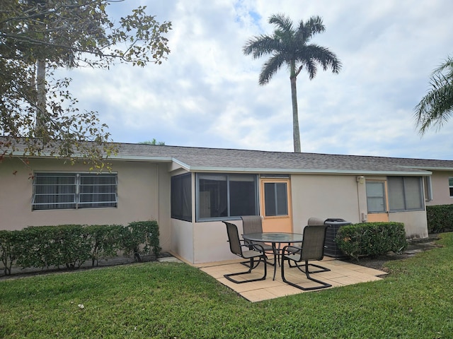 rear view of property featuring a yard, a patio, cooling unit, and a sunroom