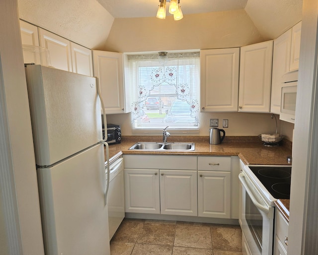 kitchen with vaulted ceiling, white cabinetry, sink, and white appliances