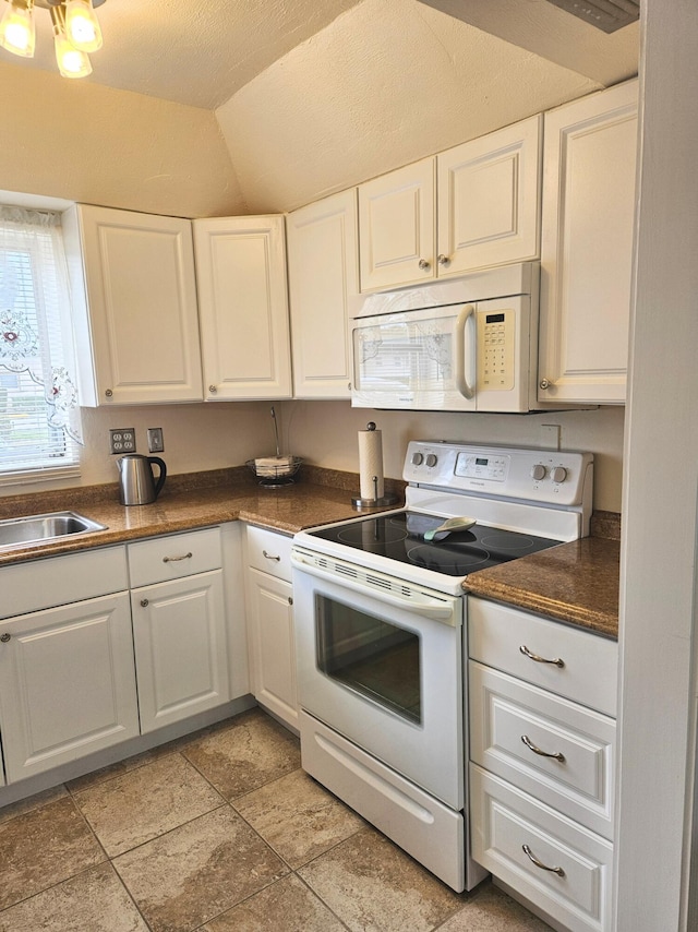 kitchen featuring white cabinets, lofted ceiling, white appliances, and sink