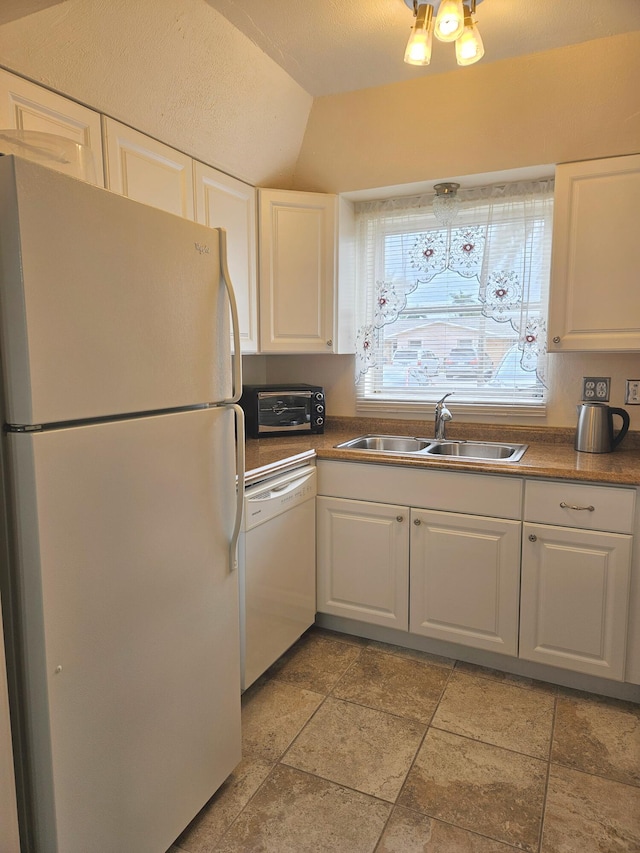 kitchen featuring white appliances, white cabinetry, vaulted ceiling, and sink