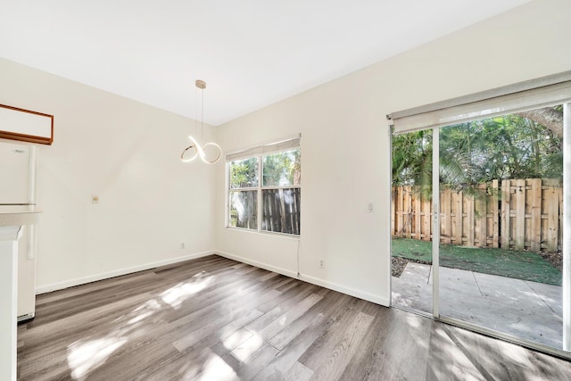 unfurnished dining area featuring hardwood / wood-style flooring and a notable chandelier