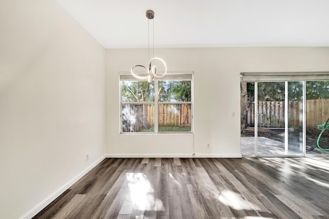 unfurnished dining area featuring dark hardwood / wood-style floors and a notable chandelier