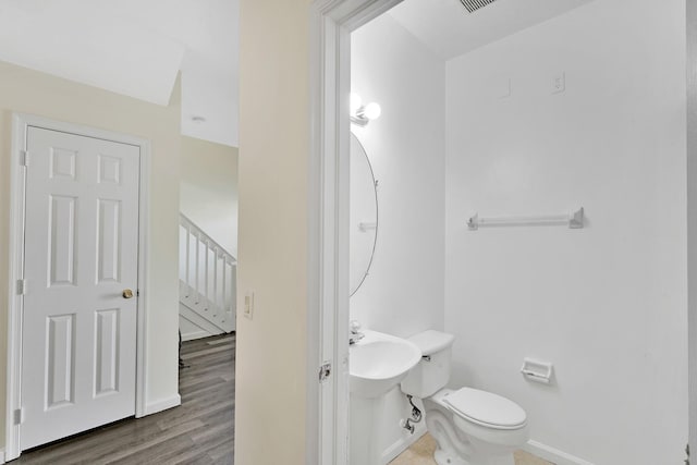 bathroom featuring hardwood / wood-style floors, toilet, and sink