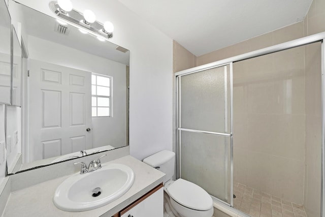 bathroom featuring vanity, an enclosed shower, and toilet