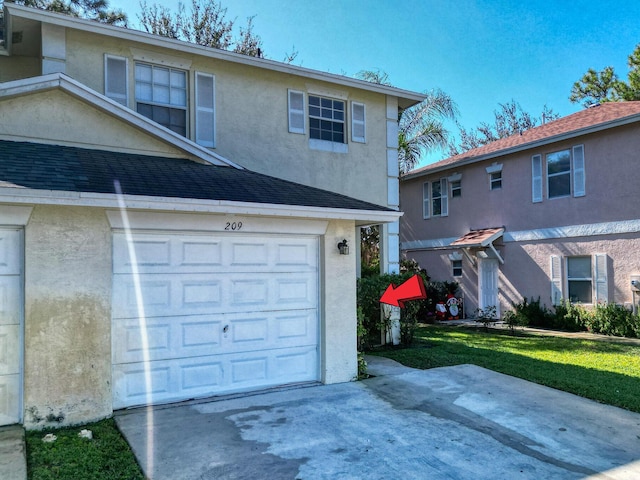 view of property with a front lawn and a garage