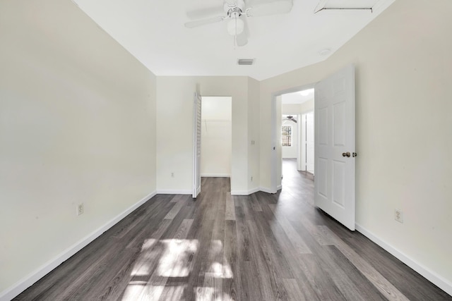 empty room featuring dark hardwood / wood-style flooring and ceiling fan