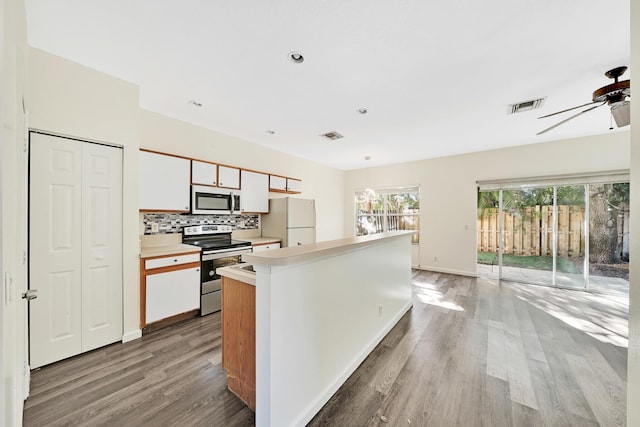 kitchen featuring white cabinets, appliances with stainless steel finishes, light hardwood / wood-style floors, and ceiling fan