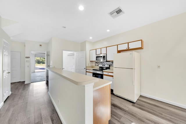 kitchen with white cabinetry, a center island, tasteful backsplash, appliances with stainless steel finishes, and light wood-type flooring