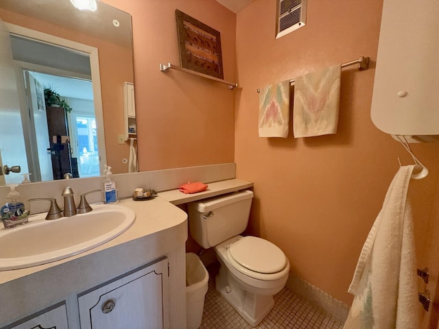 bathroom with tile patterned flooring, vanity, and toilet