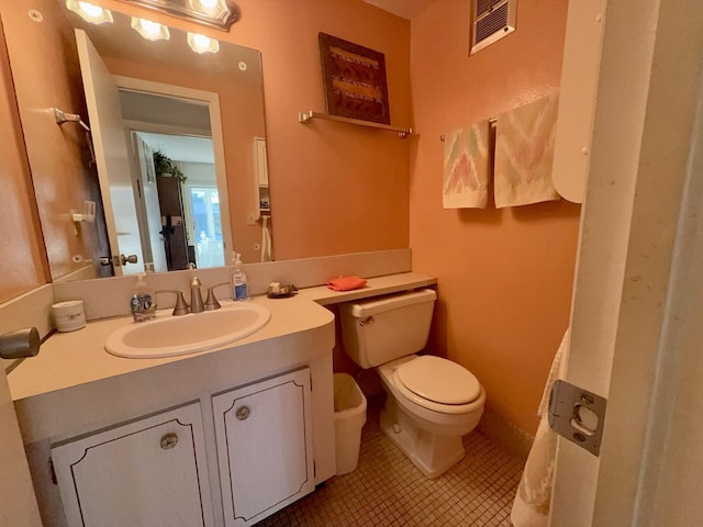 bathroom featuring tile patterned flooring, vanity, and toilet