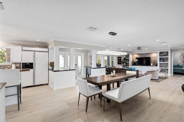 dining space with crown molding, ceiling fan, and light wood-type flooring