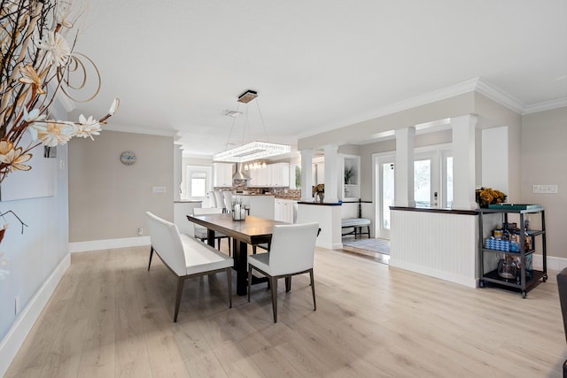 dining space with french doors, crown molding, and light hardwood / wood-style flooring