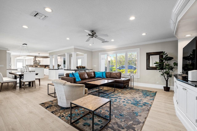 living room with a textured ceiling, ceiling fan, light wood-type flooring, and crown molding