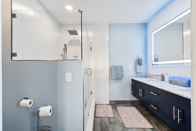 bathroom with wood-type flooring, vanity, and a shower with door