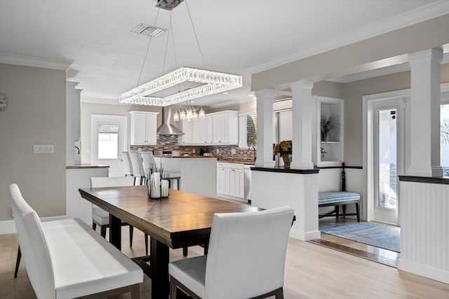 dining area featuring light hardwood / wood-style flooring, an inviting chandelier, and crown molding