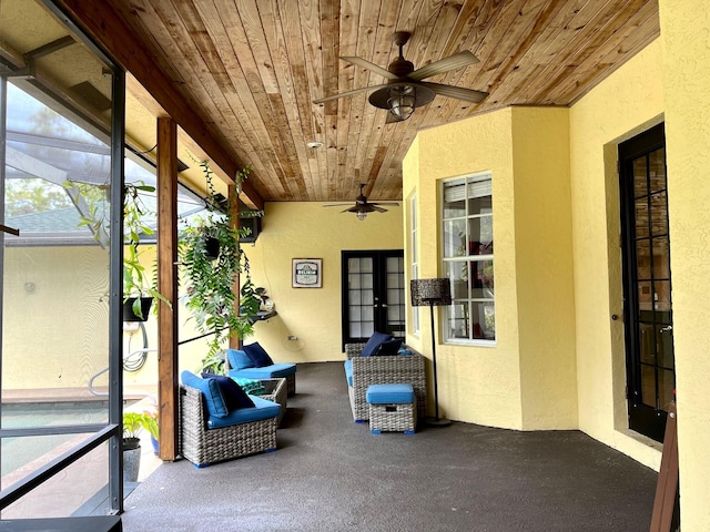 unfurnished sunroom with ceiling fan and wood ceiling