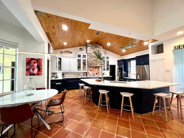 kitchen featuring a kitchen breakfast bar, wooden ceiling, high quality fridge, and a spacious island