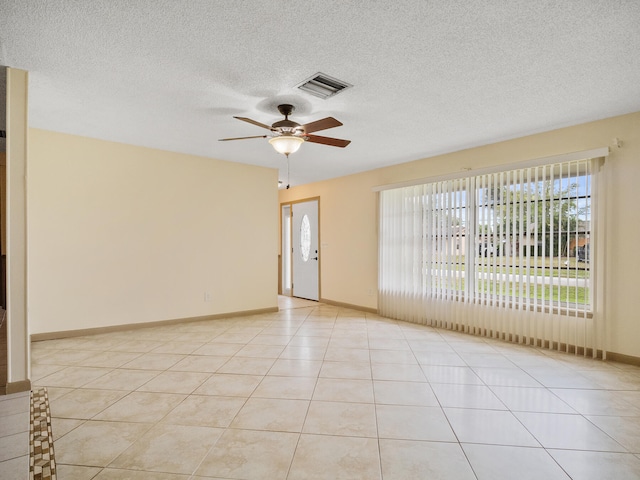 tiled empty room with a textured ceiling and ceiling fan