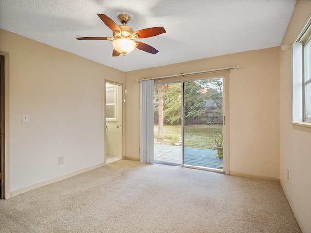 unfurnished room with ceiling fan, light colored carpet, and a textured ceiling