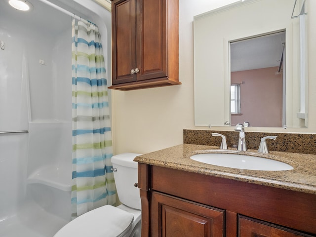 bathroom featuring vanity, curtained shower, and toilet