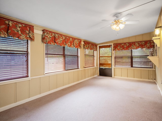 carpeted empty room featuring vaulted ceiling, ceiling fan, and a healthy amount of sunlight