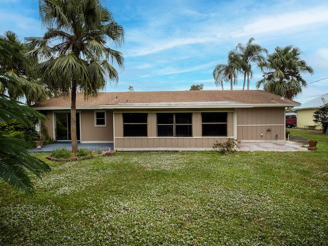 back of house with a lawn and a patio area