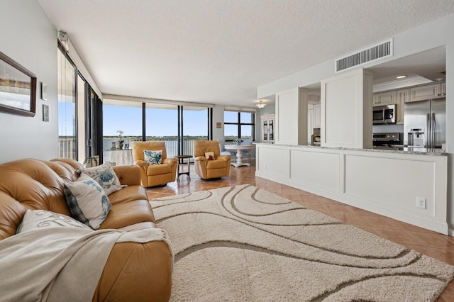 tiled living room with a wall of windows and a textured ceiling