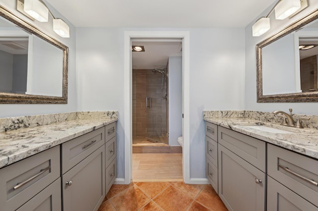 bathroom featuring vanity, toilet, tile patterned flooring, and a shower with door