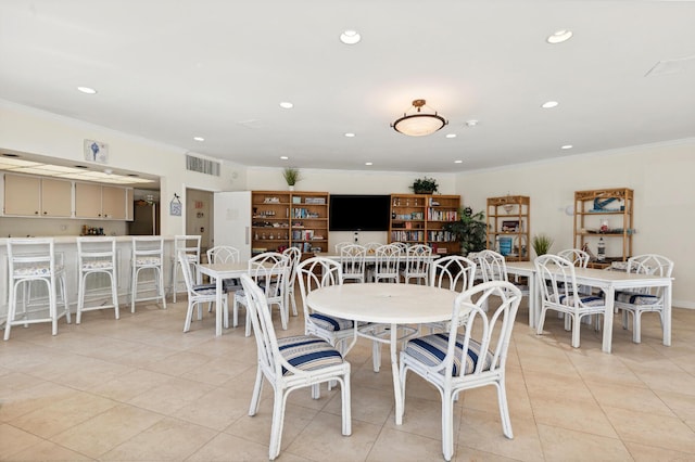 tiled dining room featuring crown molding