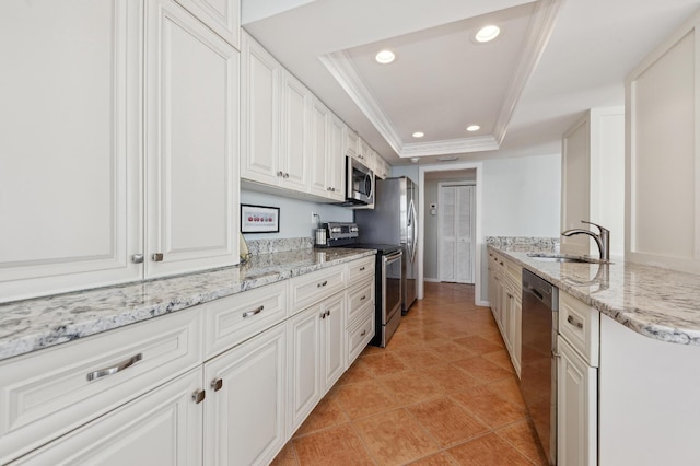 kitchen featuring sink, white cabinetry, light stone counters, a tray ceiling, and stainless steel appliances