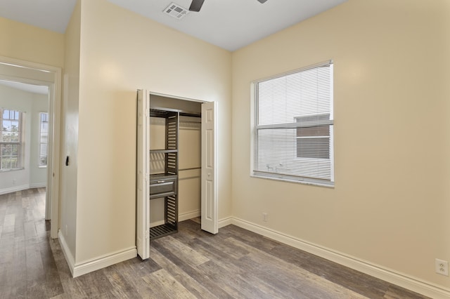 unfurnished bedroom featuring dark hardwood / wood-style flooring, a closet, and ceiling fan