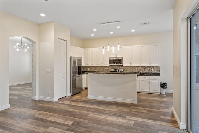 kitchen featuring white cabinetry, tasteful backsplash, dark hardwood / wood-style floors, decorative light fixtures, and appliances with stainless steel finishes