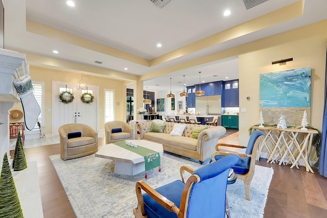 living room with a raised ceiling and hardwood / wood-style floors