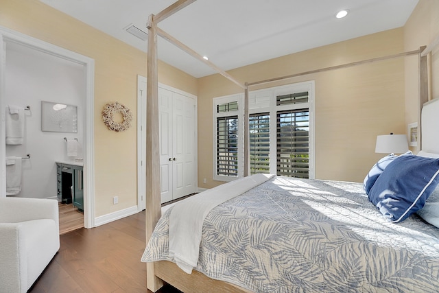 bedroom with dark hardwood / wood-style floors and connected bathroom