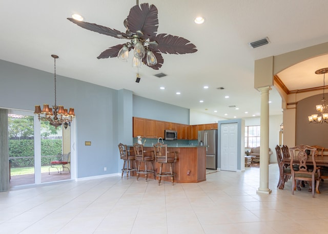 kitchen with ornate columns, plenty of natural light, stainless steel appliances, and decorative light fixtures