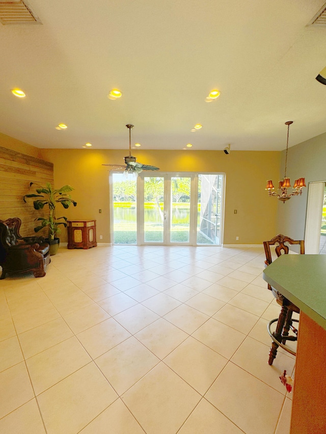 interior space featuring ceiling fan with notable chandelier