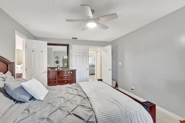 bedroom with light tile patterned floors, a textured ceiling, and ceiling fan